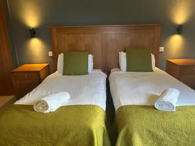 a bedroom with two beds with green pillows at Rowardennan Hotel in Rowardennan