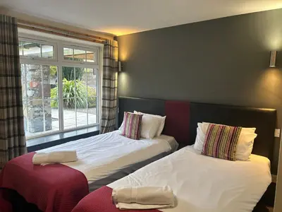 two beds in a room with a window at Rowardennan Hotel in Rowardennan
