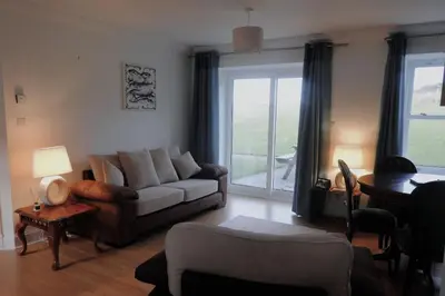a living room with a couch and a table at Harebell Cottage in Killean