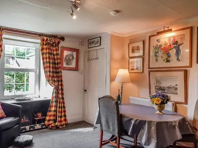 a living room with a table and a window at Ivy Cottage in Crieff