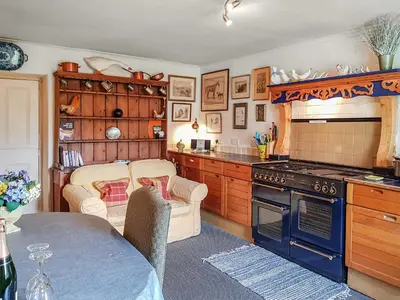 a kitchen with a table and a stove at Ivy Cottage in Crieff