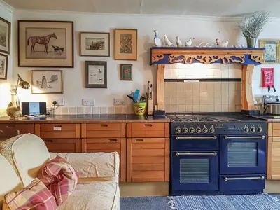 a kitchen with a blue stove and a couch at Ivy Cottage in Crieff