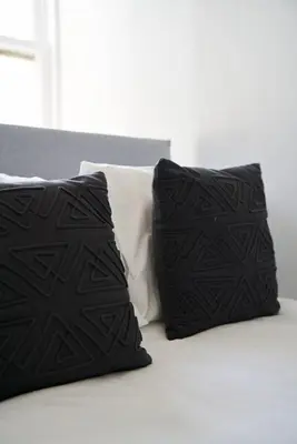 two black pillows sitting on top of a bed at 1 BDR Apt By Caledonia Luxe Stays Short Lets & Serviced Accommodation Lanark in Douglas