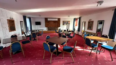 an empty room with tables and chairs in a building at The Bruce Hotel in Newton Stewart