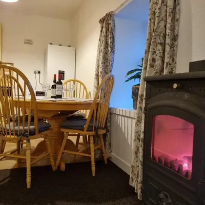 a dining room with a table and a fireplace at Killean Farmhouse Cottages in Auchnangoul
