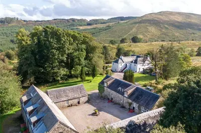 an aerial view of a house in the hills at Killean Farmhouse Cottages in Auchnangoul