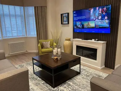 a living room with a tv and a couch and a table at Luxury 2 Bedroom Cottage in West Calder