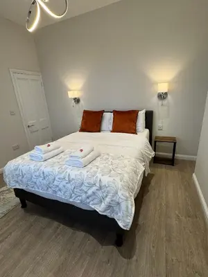 a bedroom with a bed with two towels on it at Luxury 2 Bedroom Cottage in West Calder
