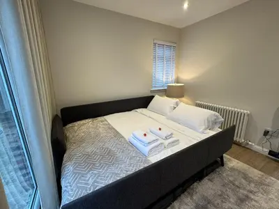 a bedroom with a bed with two towels on it at Luxury 2 Bedroom Cottage in West Calder