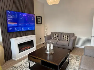 a living room with a fireplace and a tv at Luxury 2 Bedroom Cottage in West Calder