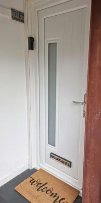 a door with a welcome mat in front of it at Cove Bay 1 Bed Flat in Largs