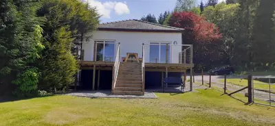 a house with a deck with a staircase on it at Highland Haven, Glencoe in Ballachulish