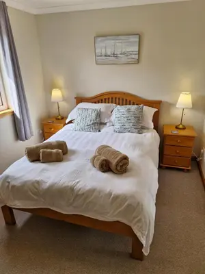 a bedroom with a bed with towels on it at Kings Reach - Crinan Cottage in Lochgilphead
