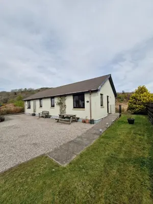 a white house with a picnic table in front of it at Kings Reach - Crinan Cottage in Lochgilphead