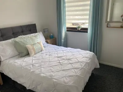 a bedroom with a white bed with a window at Argyll Apartment Loch Lomond in Balloch