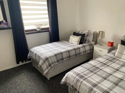 a bedroom with two beds and a window at Argyll Apartment Loch Lomond in Balloch