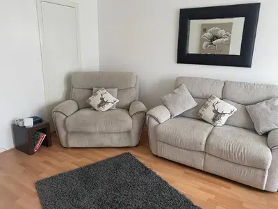 a living room with a couch and a chair at Argyll Apartment Loch Lomond in Balloch