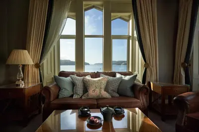 a living room with a couch and a large window at Oban Bay Hotel in Oban