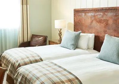 a hotel room with two beds and a chair at Oban Bay Hotel in Oban