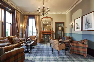 a living room with a couch and a fireplace at Oban Bay Hotel in Oban