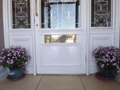 a white door with two vases with purple flowers at Palace Hotel - Small Hotel in Oban