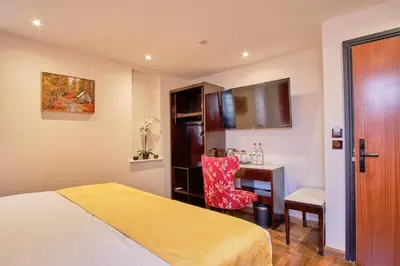 a bedroom with a bed and a desk and a chair at Muthu Oban Regent Hotel in Oban