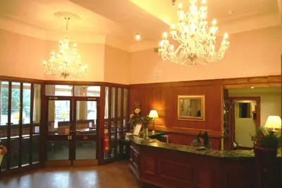 a lobby with two chandeliers and a bar in a building at The Royal Hotel in Oban
