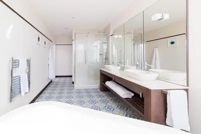 a bathroom with two sinks and a large mirror at The Perle Oban Hotel & Spa in Oban