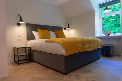 a bedroom with a bed with yellow pillows and a window at Combie Lane Apartment in Oban