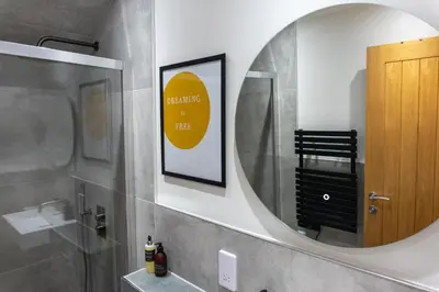 a bathroom with a mirror and a sink at Combie Lane Apartment in Oban