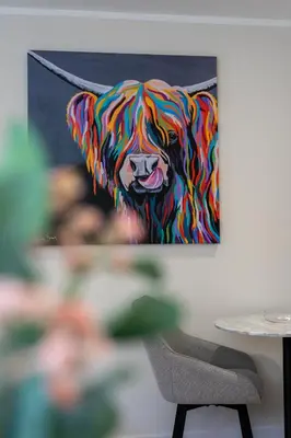 a painting of a colorful dog on a wall at Combie Lane Apartment in Oban