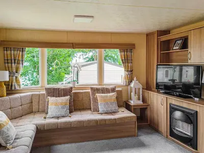 a living room with a couch and a television at The Meadows in Wemyss Bay