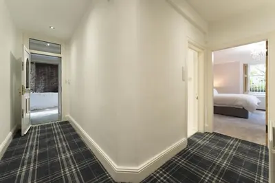 a hallway with a bedroom with a bed and a window at The Lindsay House in Stirling