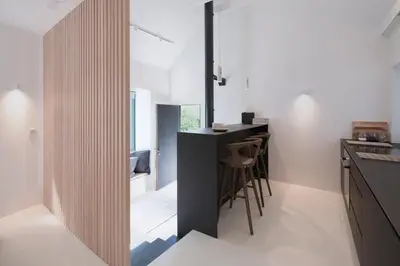 a kitchen with a black island in a room at Eastside - Architect designed retreat with wood-fired sauna in Penicuik