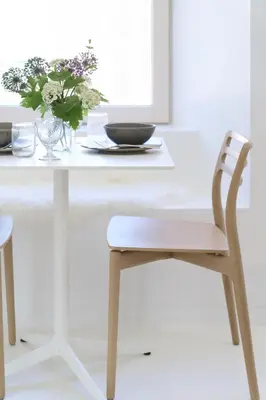 a white table with a chair and a vase of flowers at Eastside - Architect designed retreat with wood-fired sauna in Penicuik