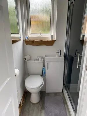 a small bathroom with a toilet and a sink at Devon River Glamping Pods in Alloa