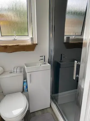 a bathroom with a toilet and a sink and a shower at Devon River Glamping Pods in Alloa