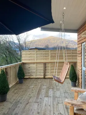 a porch with a hammock on a wooden deck at Devon River Glamping Pods in Alloa