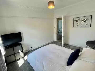 a bedroom with a bed and a flat screen tv at Large 2 bed near Glasgow Airport in Paisley