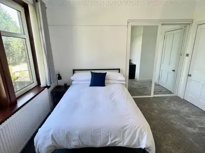 a bedroom with a white bed with a blue pillow at Large 2 bed near Glasgow Airport in Paisley