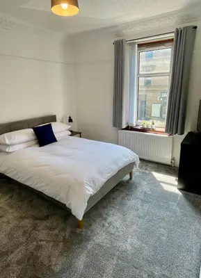 a bedroom with a large white bed with a window at Large 2 bed near Glasgow Airport in Paisley