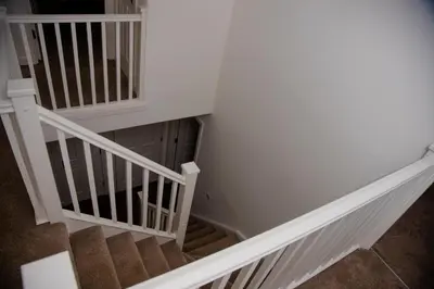 a stairwell with white railings and a staircase withbrown carpet at Beautiful 5 Bedroom House in Glasgow in Cambuslang