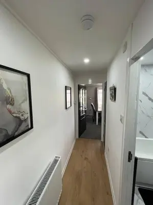 a hallway of a house with white walls and wood floors at Erskine Apartment in Erskine