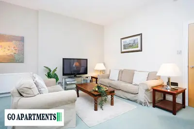 a living room with two couches and a tv at Large 2 Bed Edinburgh City Centre Apartment - FREE Parking in Edinburgh