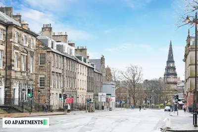 a city street with buildings and a clock tower at Large 2 Bed Edinburgh City Centre Apartment - FREE Parking in Edinburgh