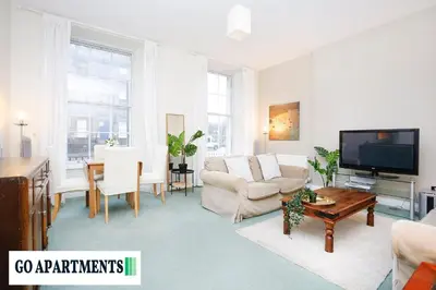 a living room with a couch and a tv at Large 2 Bed Edinburgh City Centre Apartment - FREE Parking in Edinburgh