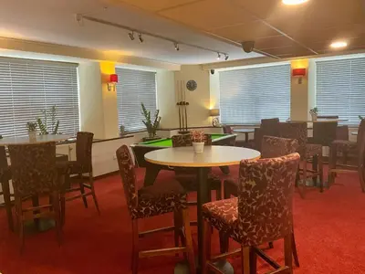 a dining room with tables and chairs and windows at Britannia Inn Glasgow in Glasgow
