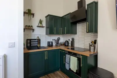 a kitchen with green cabinets and a counter top at Spacious 3 Bedroom Home In Glasgow - Free Parking in Glasgow