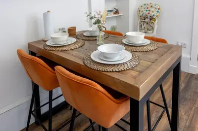 a dining room table with bowls and plates on it at Spacious 3 Bedroom Home In Glasgow - Free Parking in Glasgow