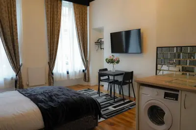 a hotel room with a bed and a washing machine at Novana Aparthotel in Glasgow